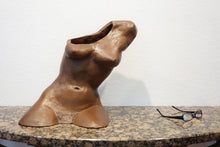 Laden Sie das Bild in den Galerie-Viewer, Terra-cotta hollow sculpture of a woman's torso sitting on a granite table, front view with pair of eyeglasses lying on table for size comparison