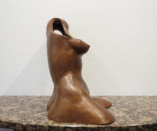 Laden Sie das Bild in den Galerie-Viewer, Terra-cotta hollow sculpture of a woman's torso sitting on a granite table, showing profile of body right side