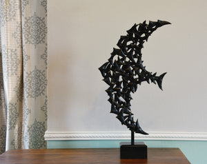 This shows the birds in flight in the shape of a bird, facing  / flying to the left.  This one-of-a-kind bronze sculpture rests on a dresser table top.  Art by Kelly Borsheim