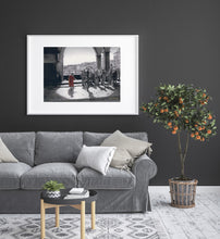 Cargar imagen en el visor de la galería, charcoal drawing of people on an old bridge in Florence Italy with Tuscan landscape in background, shown in grey living room with an orange tree as decorations beside the couch