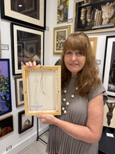 將圖片載入圖庫檢視器 A female artist with shoulder-length light brown hair stands in an art gallery holding up the back of a framed canvas. The canvas has a light natural wood frame, a beige backing board, and a hanging string.