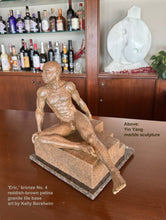 將圖片載入圖庫檢視器 White marble sculpture Yin Yang is on a shelf in the background of a home bar.  In the foreground is a beautiful reddish-brown opaque patina create a more skin-like (non-reflective) feel of this bronze sculpture of a young man.  He is bald and muscular, seated on a block that has curving steps on the far corner, perhaps similar to a pool entrance.