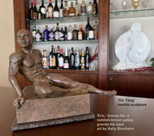 將圖片載入圖庫檢視器 Bronze sculpture of muscular bald man seated on a home bar.  Behind on the right is a marble sculpture Yin Yang by the same artist , Kelly Borsheim