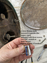 Laden Sie das Bild in den Galerie-Viewer, Hand holding a tool with text on mounting Gemini Bronze to a granite disc.