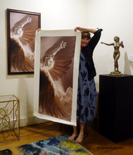 Carica l'immagine nel visualizzatore di Gallery, Artist Kelly Borsheim holds up the 50-inch tall print of her Icarus painting up against the length of her body.  The framed 40-inch tall version hangs on the wall behind her.  To the right is Kelly's sculpture "Sirenetta" aka The Little Mermaid nude woman sculpture.