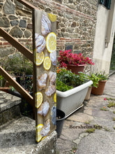 Carica l'immagine nel visualizzatore di Gallery, front and left side view of Italian breakfast painting as seen leaning against the stair rail to the artist's front door. colorful plants are in the background