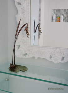 Another modern bathroom shot with the tabletop bronze sculpture of two small male figures and nature.