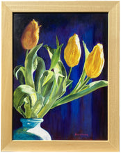 Carica l'immagine nel visualizzatore di Gallery, Framed still life painting of yellow tulips with green leaves in a blue vase against a dark blue background, enclosed in a light wood frame.