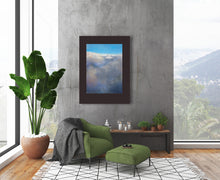 Load image into Gallery viewer, print of clouds from top view is framed in wide dark frame in this loft apartment that loves Nature living.
