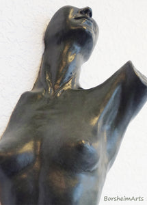 Detail image of the breasts and neck and lower face of the torso composition that is mounted on a wall.