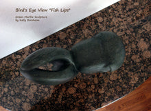 Load image into Gallery viewer, Bird's eye view of the stone carving Fish Lips by Kelly Borsheim, resting on a granite tabletop.