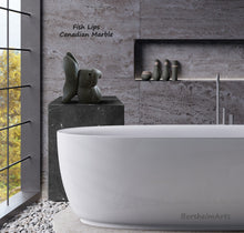 Load image into Gallery viewer, Put a little fun and playfulness into this Elegant bathroom with grey stone walls and a large white bathtub, one large window on left, with stone sculpture Fish Lips on a pedestal of stone