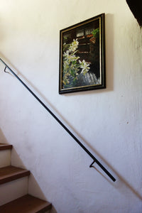 Floral oil painting of backlit jasmine flowers adds a focal point to this staircase corridor wall art.