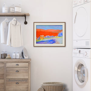 the original artwork Orange Tuscan Hills pastel painting is shown here in an example frame hanging on the wall of a neutral decor laundry room... adding a splash of color!