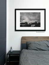 Cargar imagen en el visor de la galería, Shown here is the charcoal and pastel drawing Splash, inspired by the Cinque Terre in Italy, framed with a wide white mat and thin black line frame.  The art is hung in a man's bedroom.