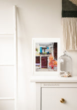 Load image into Gallery viewer, This pastel painting of old brown doors and hanging laundry in Venice, Italy, looks great in this boho decor bedroom.
