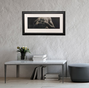 Entwined, framed charcoal drawing of man with interlaced fingers, as it might look in a home