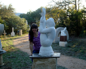 Artist Kelly Borsheim with Gymnast marble figure athlete carving and behind to the right is her Stargazer marble woman looking to the skies