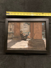 Load image into Gallery viewer, Here you see a tape measure alongside the framed art.  This is intended to give you a much better idea about the size of this pastel drawing of a young woman sitting outside in, leaning against Italian square columns in a piazza in Florence, Italy.  She is reading a book, relaxing in the winter sunshine.  Pastel art by Kelly Borsheim
