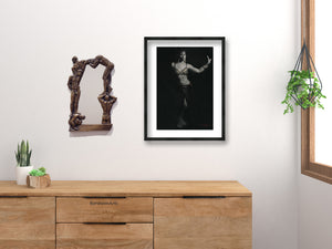 Oh Boy! Bronze Mirror of Nude Men shown next to art print by Kelly Borsheim over a dresser of wood color