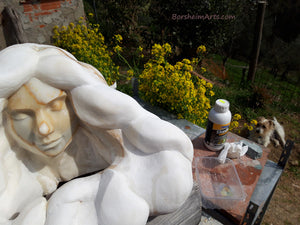 Peaceful expression on Serenity, a marble portrait of a young woman with flowing, wavelike hair