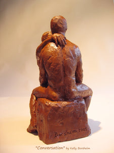 view of the husband's back with the wife's hand draped over his left shoulder.  Artist Borsheim signed the terra-cotta sculpture at the base or bottom.  Conversation, romantic gift art idea.