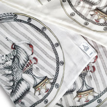 Charger l'image dans la galerie, detail image of designer scarf Tiger Shoe foulard material, shown here the artist Dragana Adamov's logo tag sewn into one corner of the elegant scarf featuring hand-drawn tigers leaping from around a circus-inspired fantasy shoe