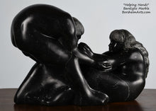 Load image into Gallery viewer, note the space between the woman's hand and his face Helping Hands by Kelly Borsheim Couple Art Carved from a black Marquina marble, this sculpture depicts a man bending over forward to help a seated woman stand up.  Her hands reach up towards his bearded face, but it is the moment before she is close enough to reach him. Note the space between her fingers and his face.