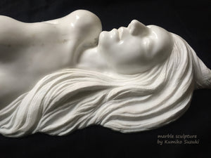 Detail marble portrait sculpture of a woman with long flowing hair by Japanese artist Kumiko Suzuki