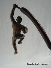 Load image into Gallery viewer, The Unwritten future... a man hangs on with one arm while his body swings on the tip of a cattail.  bronze sculpture that contemplates choices
