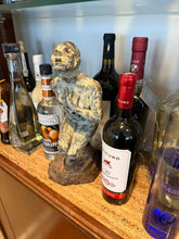 Cargar imagen en el visor de la galería, Statue of a figure in agony on a bar shelf with various bottles of alcohol.

