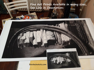 Black and white fine art print of a charcoal drawing of a circular wooden oval frame leaning on a stacks of antique books with text about available sizes and a link in the description.