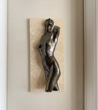 Load image into Gallery viewer, A bronze-finished sculpture of a nude female figure mounted on a rectangular beige stone tile, displayed against a neutral beige wall.
