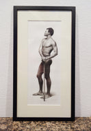 Resting on a granite table and leaning against a white textured wall is a framed black and white original drawing of a standing man holding a cane, looking to our left.