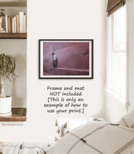 Load image into Gallery viewer, Pink walls of Marrakesh surround a shy boy in white T-shirt looking down while he pretends not to follow the artist.  This is a print from a pastel drawing Another World, shown in a boho bedroom scene framed on the wall.
