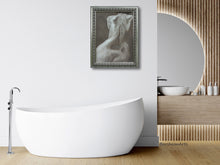 將圖片載入圖庫檢視器 Modern bathroom with a white freestanding bathtub, framed elegant artwork of a woman's back on the wall, and wooden vanity.
