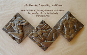 Three bronze tiles with artistic designs on a wooden surface, featuring text about product details.