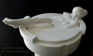 Marble sculpture of a woman lying in a small pool with legs extended out by Vasily Fedorouk against a black background.