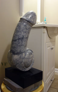 Grey marble with black veins sculpture resembling a phallic shape in a bathroom setting