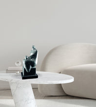 Carica l&#39;immagine nel visualizzatore di Gallery, Abstract sculpture on a marble table with a modern sofa in the background
