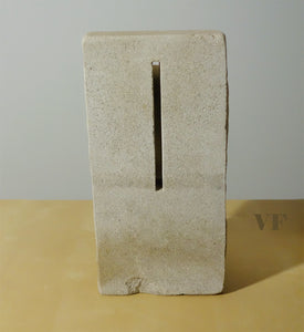 Rectangular stone block with a cutout on a beige surface