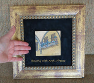 Small painting of architectural detail in Piazza Annunciata in Florence, Italy or Firenze, Italia.  The artist's hand next to the art shows the actual dimensions of this 4 x 4 inch miniature painting.
