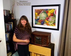 Woman standing next to a framed pastel artwork of fruits and vegetables in a room with books and an antique radio.