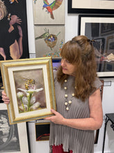 將圖片載入圖庫檢視器 A woman in a gray pleated top holds up a framed painting of a bee on a Bradford Pear white flower. The setting is an art gallery or studio with other framed artworks hanging on the wall behind her.
