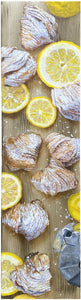 Tall vertical painting of lemon slices with the Italian pastry called sfogliatella.  the food sits on a wooden cutting board and you see a Moka Italian coffee maker.  Painting is of the aerial view of this composition.  80 x 20 cm by artist Kelly Borsheim