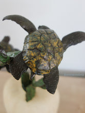 Charger l&#39;image dans la galerie, Detail of yellow and dark green speckled patina finish of the turtle shell in bronze sculpture of two sea turtles swimming near kelp.
