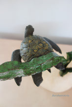 Charger l&#39;image dans la galerie, Bronze turtle sculpture on a kelp branch with a blurred background

