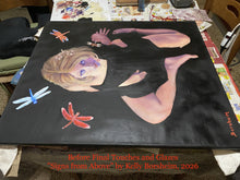 Laden Sie das Bild in den Galerie-Viewer, A large black canvas painting displayed on a table in an art studio, featuring a surreal figure with detached limbs, a face with purple eyes and blonde hair, and five flying dragonflies. Red text at the bottom reads 'Before Final Touches and Glazes "Signs from Above" by Kelly Borsheim, 2026'.
