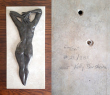 Load image into Gallery viewer, Under a different, softer lighting, #21 in the limited edition bronze small &quot;Ten&quot; shows the woman&#39;s back with a silery patina and a light colored travertine stone. The right side of the image shows how each piece of art is numbered and signed by the artist on the back of the stone (and also on the back of the bronze, in case you choose not to exhibit with the stone.
