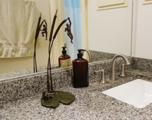 Load image into Gallery viewer, Tabletop bronze sculpture of two men on a lily pad and two cattails is shown here is a man&#39;s bathroom.  Reflected in the mirror, one sees the pose from two different points of view.
